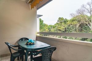 a table and chairs on a balcony with a window at CONDOMINIO LA QUERCIA in Bibione