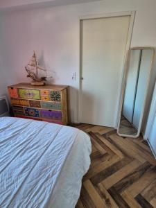 a bedroom with a bed and a dresser with a mirror at F2 Résidence L'ALIVETU in Bastelicaccia