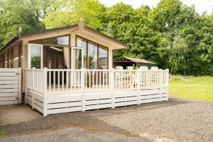 une petite maison entourée d'une clôture blanche dans l'établissement Recently updated lodge near Chester city centre - For up to 6, à Chester
