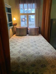 sypialnia z łóżkiem z 2 poduszkami i oknem w obiekcie Nummenpakan Pysäkki w mieście Turku
