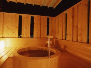 bañera de madera en una habitación con paredes de madera en Hatori, en Kaga