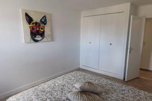 ein Zimmer mit einem Gemälde eines Hundes an der Wand in der Unterkunft apt cozy refait à neuf à 5min du centre ville in Saint-Hilaire-du-Harcouët