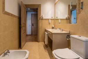 a bathroom with two sinks and a toilet and a mirror at Globales Paraíso Beach in Estepona