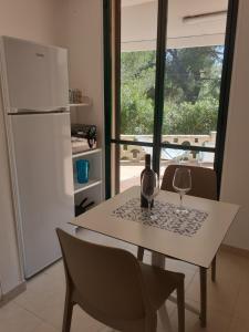 a table with a bottle and a wine glass on it at Villetta dei Fiori, vicino Spiaggia di Punta Pizzo in Gallipoli