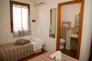 a bedroom with two beds and a bathroom with a sink at Villa I Due Pini in San Vito lo Capo