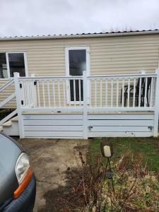 a house with a white fence in front of it at Lovely 8 Berth Caravan With Decking And Wifi In Yorkshire, Ref 71011ic in Tunstall