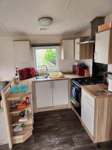a small kitchen with a sink and a stove at Lovely 8 Berth Caravan With Decking And Wifi In Yorkshire, Ref 71011ic in Tunstall