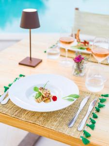 a plate of food on a table with wine glasses at Agua Green Resort in Reitani
