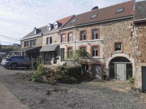 an old brick building with a car parked in front of it at La Reid, entre 2 vallées in Fraineux