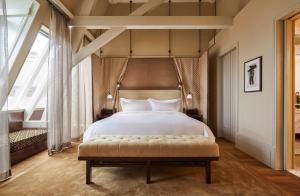 ein Schlafzimmer mit einem großen Bett und einem großen Fenster in der Unterkunft De L’Europe Amsterdam – The Leading Hotels of the World in Amsterdam
