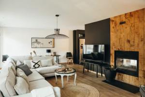a living room with a white couch and a fireplace at La Reid, entre 2 vallées in Fraineux