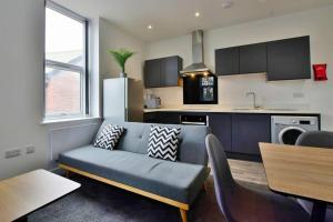 a living room with a couch and a kitchen at FREE PARKING - Charming 2-BR Flat near Salford Royal in Manchester