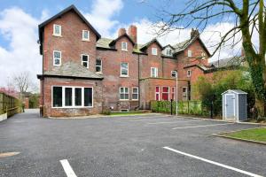 a large red brick building with a parking lot at FREE PARKING - Charming 2-BR Flat near Salford Royal in Manchester +6 photos