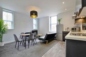 a kitchen and dining room with a table and chairs at FREE PARKING - Charming 2-BR Flat near Salford Royal in Manchester