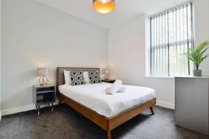 a white bedroom with a bed and a window at FREE PARKING - Charming 2-BR Flat near Salford Royal in Manchester