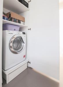 a washer and dryer in a white laundry room at La Sosta in San Siro