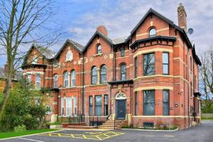 un gran edificio de ladrillo rojo con puerta negra en FREE PARKING - Charming 2-BR Flat near Salford Royal en Mánchester