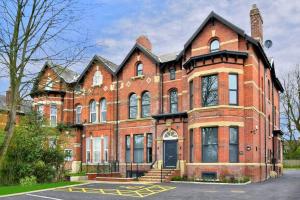 a large red brick building with a black door at FREE PARKING - Charming 2-BR Flat near Salford Royal in Manchester