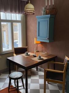 a dining room table with chairs and a blue cabinet at Nummenpakan Pysäkki in Turku