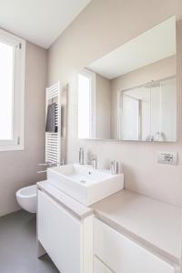 a white bathroom with a sink and a toilet at La Sosta in San Siro