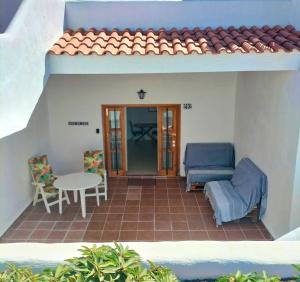 un patio con tavolo e sedie in una casa di Port Royale Los Cristianos a Los Cristianos