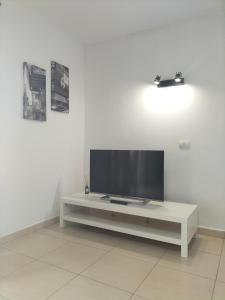 a living room with a tv on a white wall at Port Royale Los Cristianos in Los Cristianos