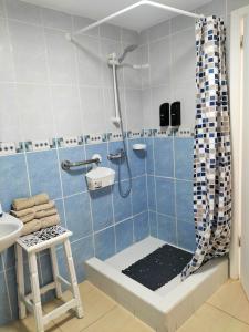 uma casa de banho azul e branca com um chuveiro e um banco em Port Royale Los Cristianos em Los Cristianos