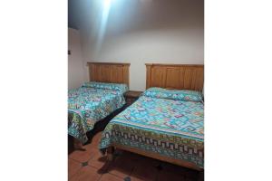 2 camas en una habitación pequeña con 2 camas individuales en OYO Los Alcatraces, en Tzintzuntzán