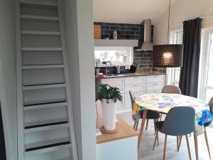 a kitchen with a table and a dining room at Nice little cottage in picturesque Tonnersa beach village, near Halmstad in Eldsberga