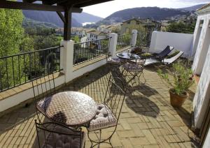balcón con sillas, mesa y vistas en Casa Rural Arroyo de la Greda en Güéjar-Sierra