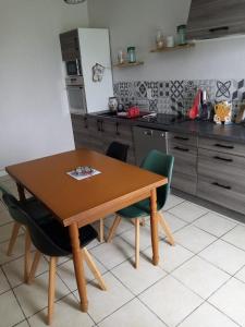 - une cuisine avec une table en bois et des chaises dans l'établissement Maison Bretonne, à Cléden-Cap-Sizun