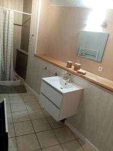 La salle de bains est pourvue d'un lavabo blanc et d'un miroir. dans l'établissement Maison Bretonne, à Cléden-Cap-Sizun