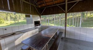 Pousada Scursel في Ibirama: غرفة مع طاولة خشبية في مبنى مع نوافذ