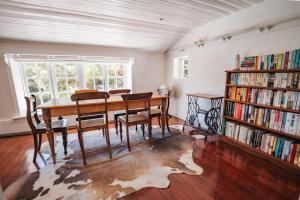 a dining room with a table and a book shelf at Beautiful Llandudno Beach Villa in Cape Town