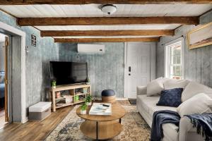 un soggiorno con un divano e una TV di Creekside Cabin w Hot Tub, Fire Pit, Grill, WiFi! a Basye