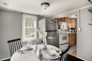una cucina con tavolo con sedie e frigorifero di Creekside Cabin w Hot Tub, Fire Pit, Grill, WiFi! a Basye