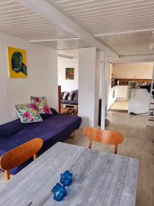 uma sala de estar com um sofá e uma mesa em Rummeligt byhus i Allinge med værelse i stueplan og havkig em Allinge