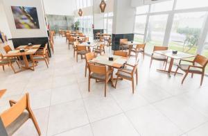 uma sala de jantar com mesas e cadeiras de madeira em BUGAN PAIVA RECIFE em Recife