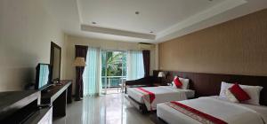 a hotel room with two beds and a television at The Pano Hotel And Residence in Ban Khlong Haeng