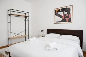 1 Schlafzimmer mit 2 weißen Betten und einem Spiegel in der Unterkunft Sofia Sunshine Serenity in Thessaloniki