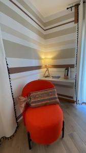 una silla roja sentada en una habitación con escritorio en La casa dei nonni al Montan - CIR SARRE 0035, en Aosta