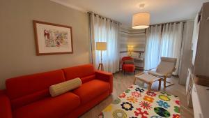 sala de estar con sofá rojo y silla en La casa dei nonni al Montan - CIR SARRE 0035, en Aosta