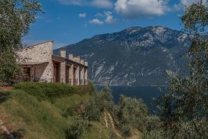 un edificio en una colina junto a un cuerpo de agua en Villa Limone, en Limone sul Garda