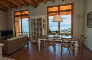 un soggiorno con tavolo, sedie e divano di Villa Limone a Limone sul Garda