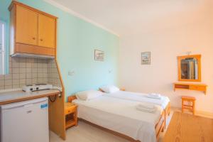 Habitación pequeña con 2 camas y cocina en Nydri Mediterraneo Apartament, en Nydri