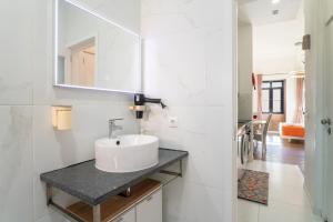 a white bathroom with a sink and a mirror at Apartamento Qian porto Centro 2 in Porto