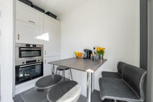 uma cozinha com uma mesa, 2 cadeiras e um forno em VitiLevu House em Southall