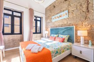 a bedroom with a bed and a brick wall at Apartamento Qian porto Centro 2 in Porto