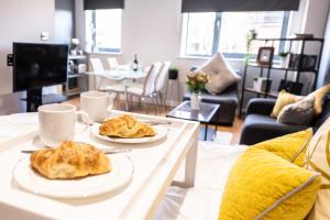 a living room with two plates of food on a table at Perfectly Located City Centre Studio Apartment - West One with FREE WIFI, GYM ACCESS, NETFLIX in Sheffield