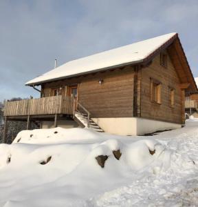 a log cabin in the snow with a pile of snow at Oberwald Chalets Ferienhaus 3 in Breungeshain